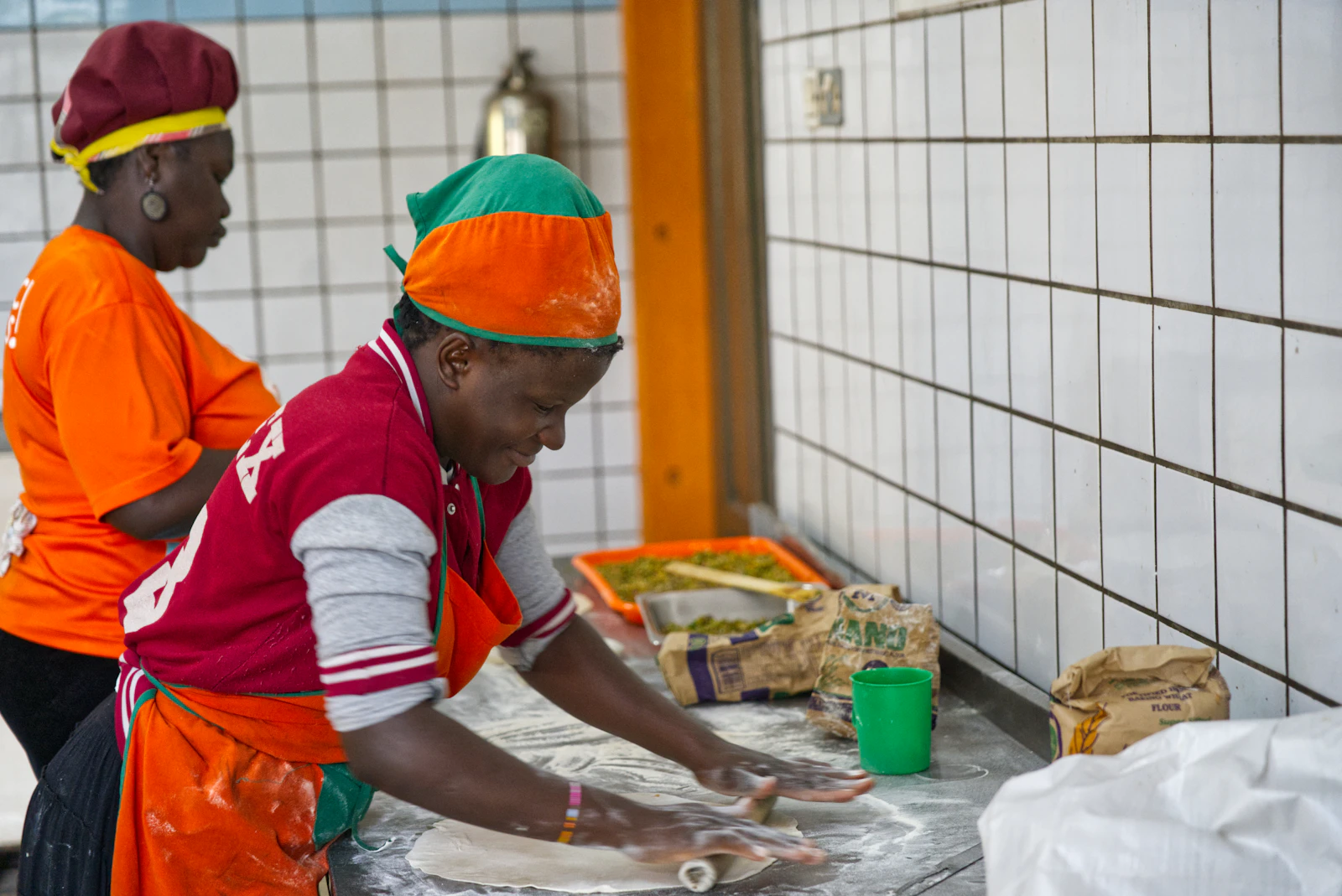 Local guide showing traditional cooking techniques in a vibrant kitchen