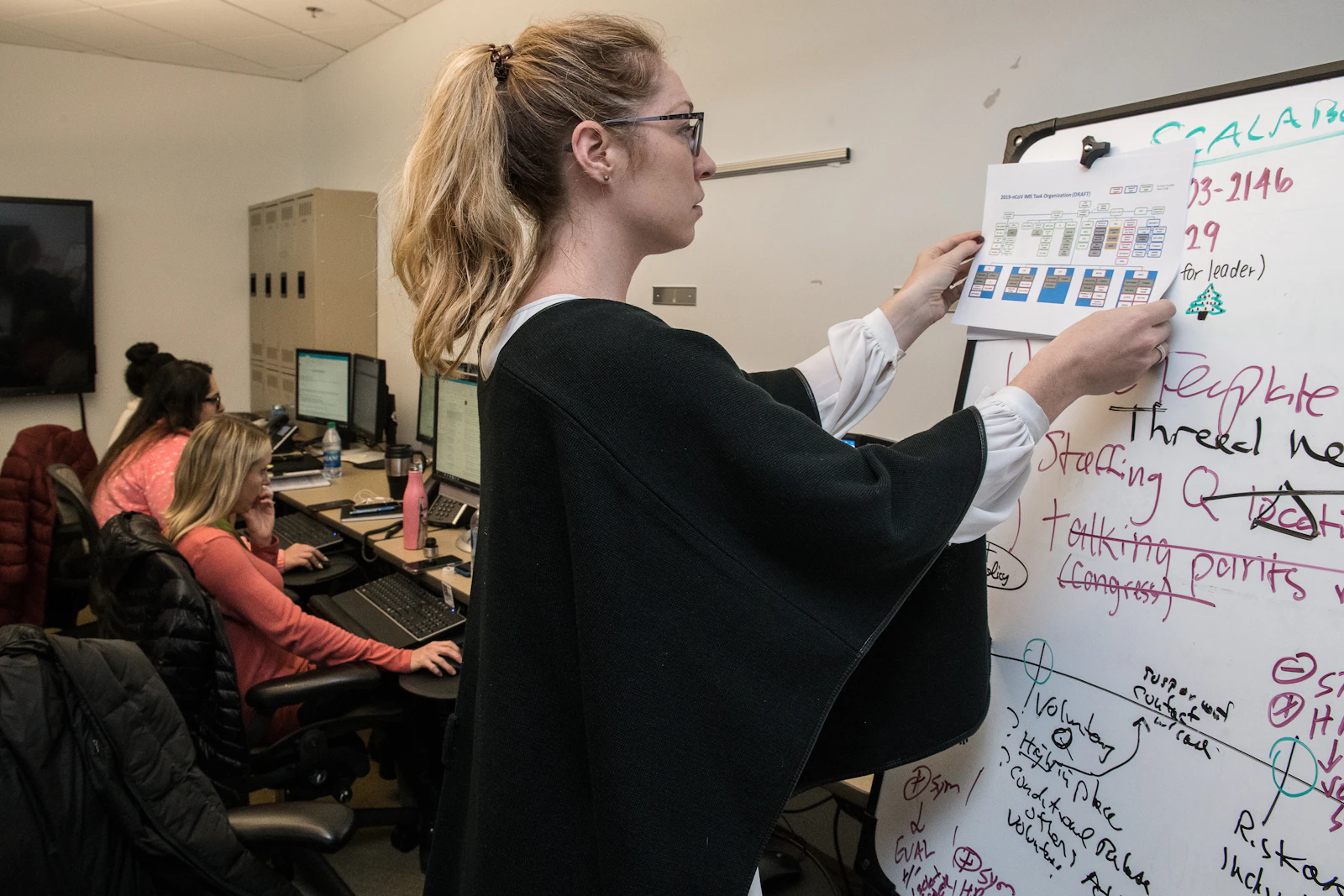 diverse startup team collaborating around whiteboard office