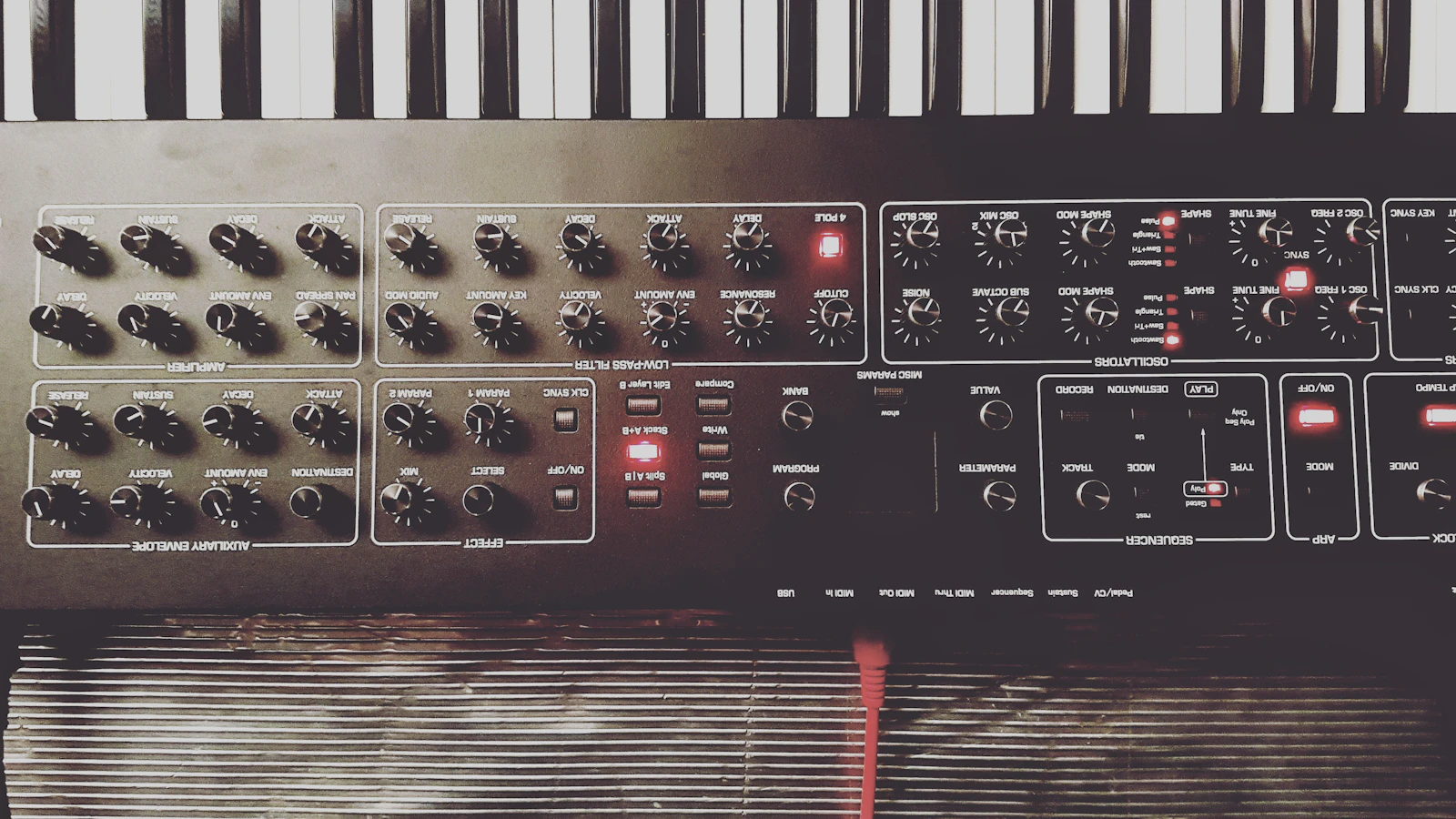 Test bench setup with multiple multimeters, scope probe, and a vintage Prophet synthesizer undergoing diagnostics